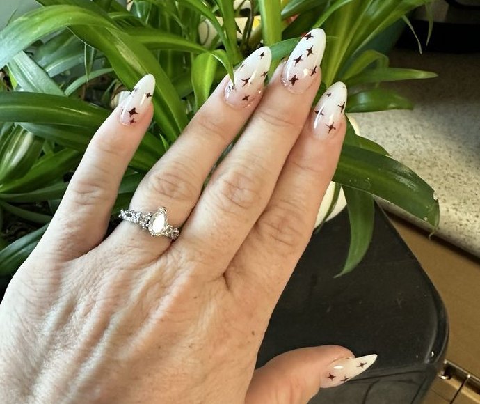Long almond nails in milky white with small dark star details